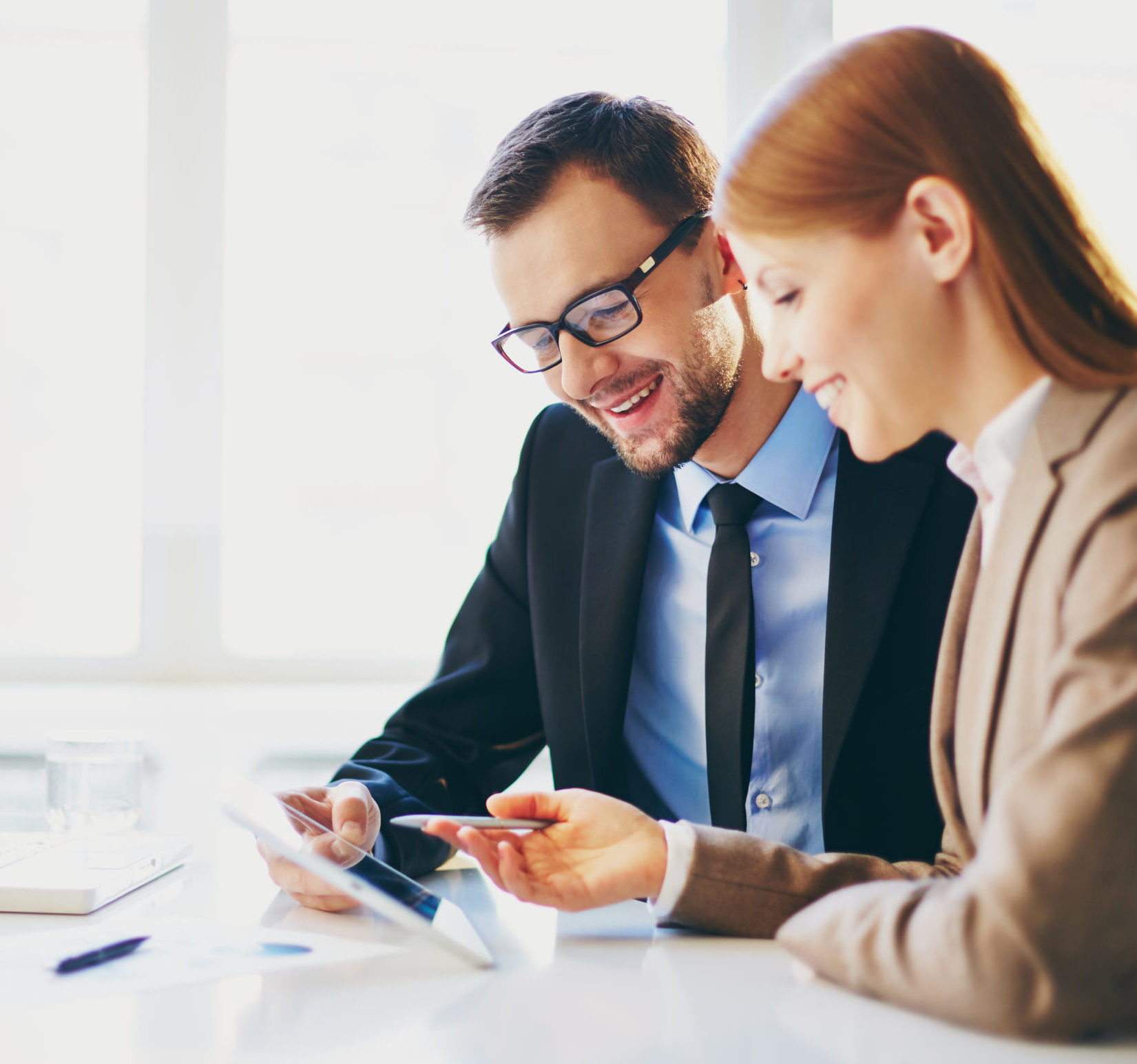 A business man and woman sharing ideas over a tablet device